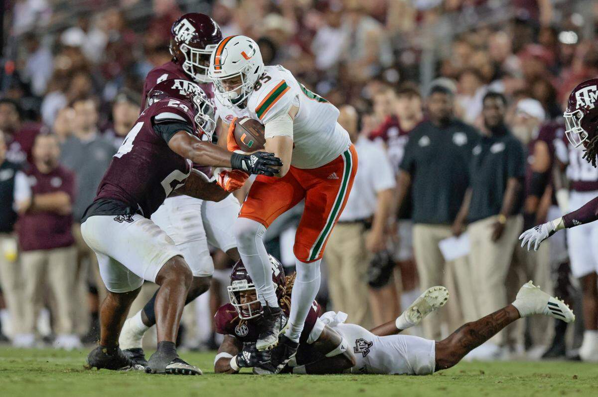 Miami Hurricanes tight end Will Mallory (85) battles Texas A&M Aggies linebacker Chris Russell Jr. (24) and teammates as Mallory earns a first down in the third quarter at Kyle Field, Bryan College Station, Texas on Saturday, September 17, 2022.