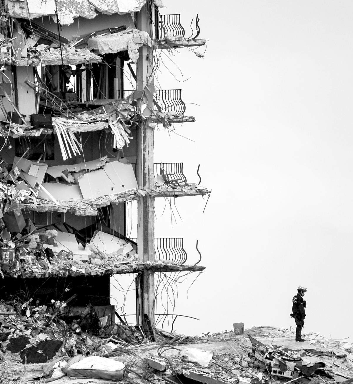 Un trabajador de rescate se encuentra sobre los escombros en las ruinas del edificio de condominios Champlain Towers South en Surfside en junio de 2021.