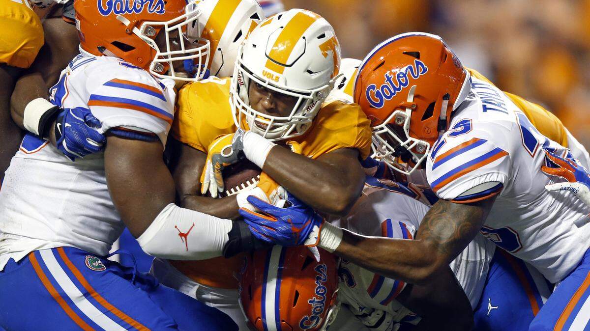 FILE -- In this Sept. 22, 2018, file photo, 
Tennessee running back Tim Jordan, center, is wrapped up by Florida defensive back Jeawon Taylor, right, and linebacker David Reese II, left, during their Sept. 22 game.