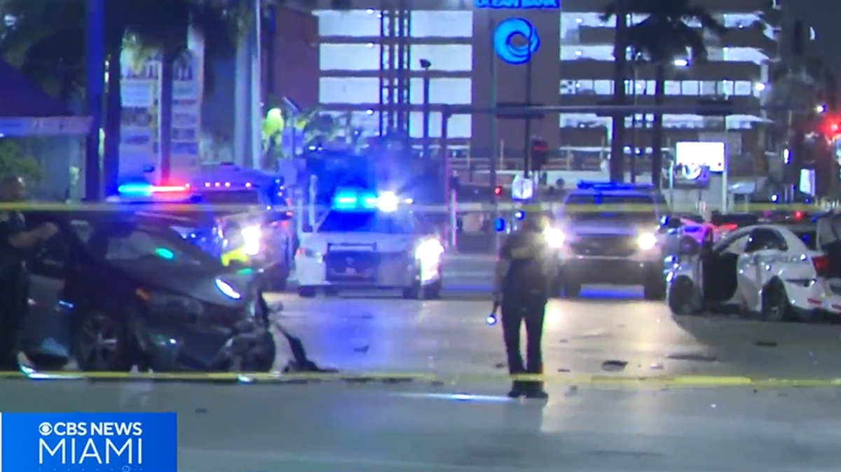 A crash involving the black Toyota on the left and the Miami police cruiser on the right injured two pedestrians.