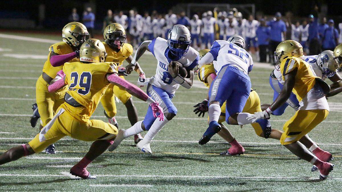 Dillard Panthers Christopher Johnson (6) carries the ball as St. Thomas Aquinas Raiders defenders move in to stop him during football game Friday, October 22, 2021 at St. Thomas Aquinas HS in Fort Lauderdale