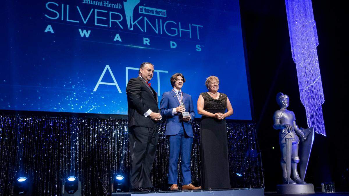 Silver Knight winner Jordan Perez, from Christopher Columbus High School, is congratulated by Alex Mena, then Interim Executive Editor of the Miami Herald & el Nuevo Herald, and Dana Banker, Senior Managing Editor of the Miami Herald, after winning in the Art category during the Miami Herald & el Nuevo Herald 65th Silver Knight Award Ceremony at the James L. Knight Center on Thursday, May 25, 2023, in downtown Miami, Fla.