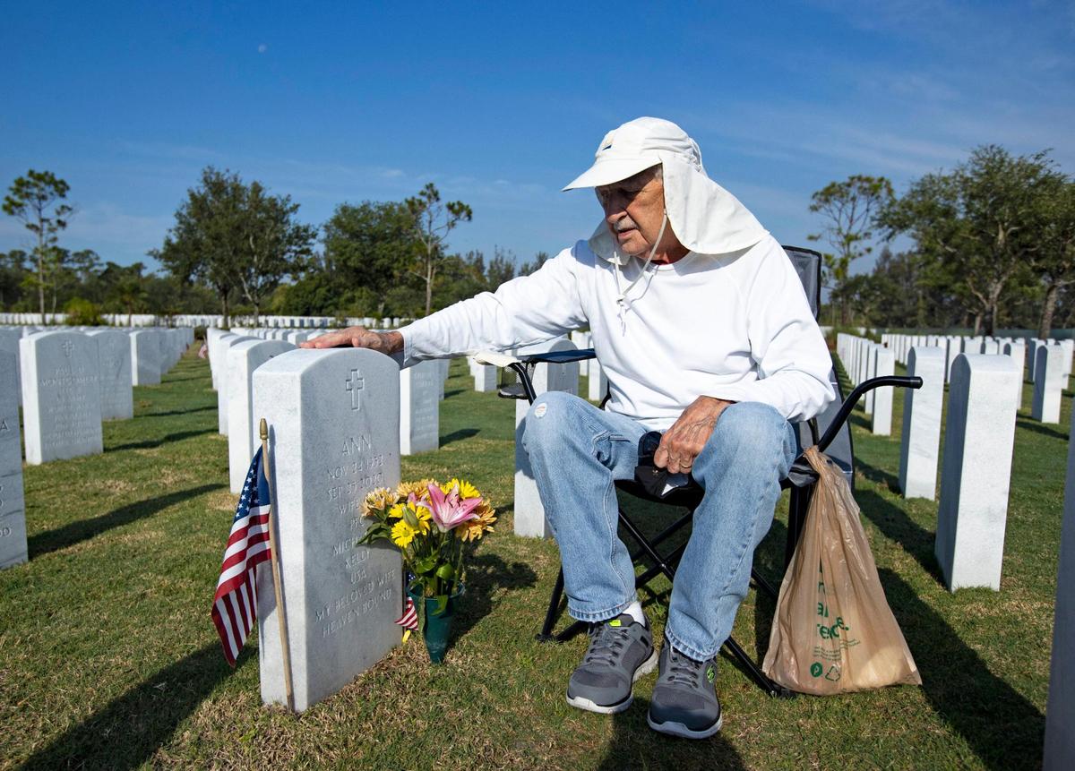 Army veteran Mike Kelly next to his wife’s tombstone at the South Florida National Cemetery Sunday in Lake Worth.
