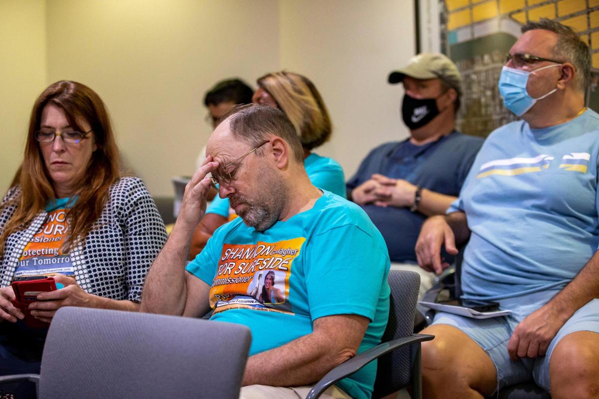 La candidata a la comisión de Surfside, Shannon Gallagher (izquierda), está sentada con sus partidarios durante una reunión en el Ayuntamiento en Surfside, Florida, el martes 8 de marzo de 2022.