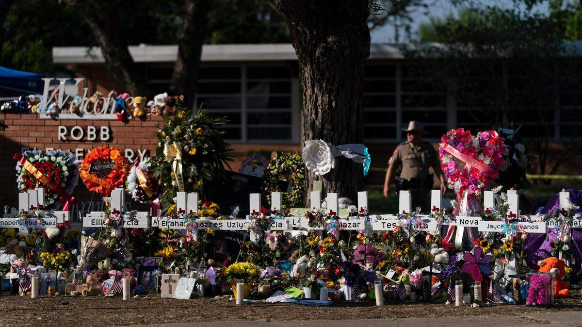 Flowers and candles are placed around crosses at a memorial outside Robb Elementary School to honor the victims killed in the school shooting in Uvalde, Texas Saturday, May 28, 2022. The gunmen in two of the nation’s most recent mass shootings, including last week’s massacre at the Texas elementary school, legally bought the assault weapons they used after they turned 18.
