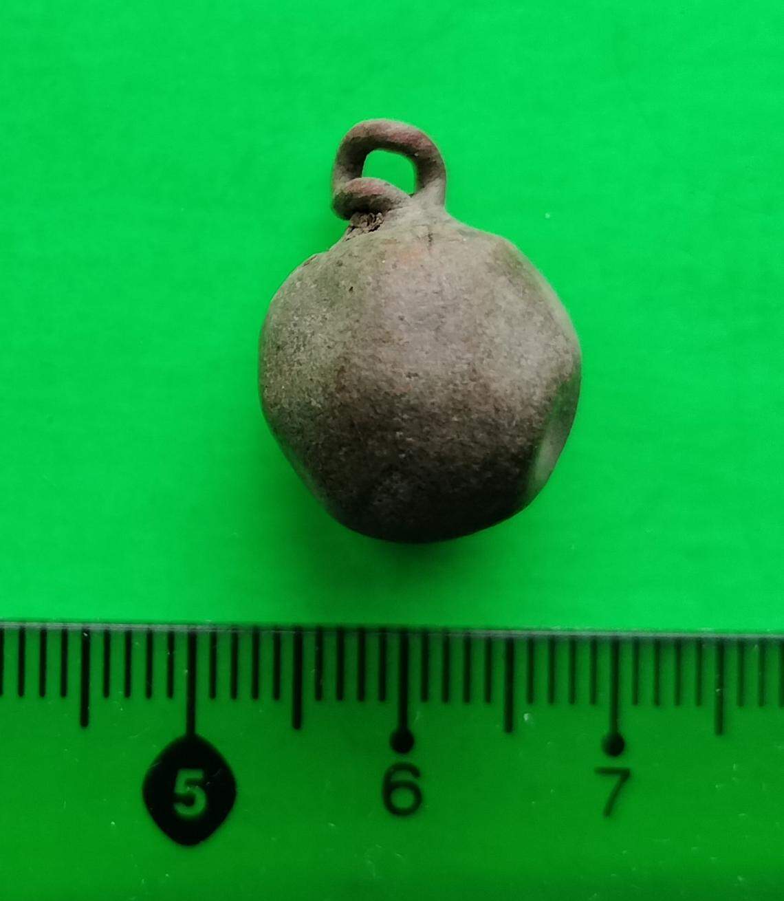 A copper button that was possibly used on a robe.