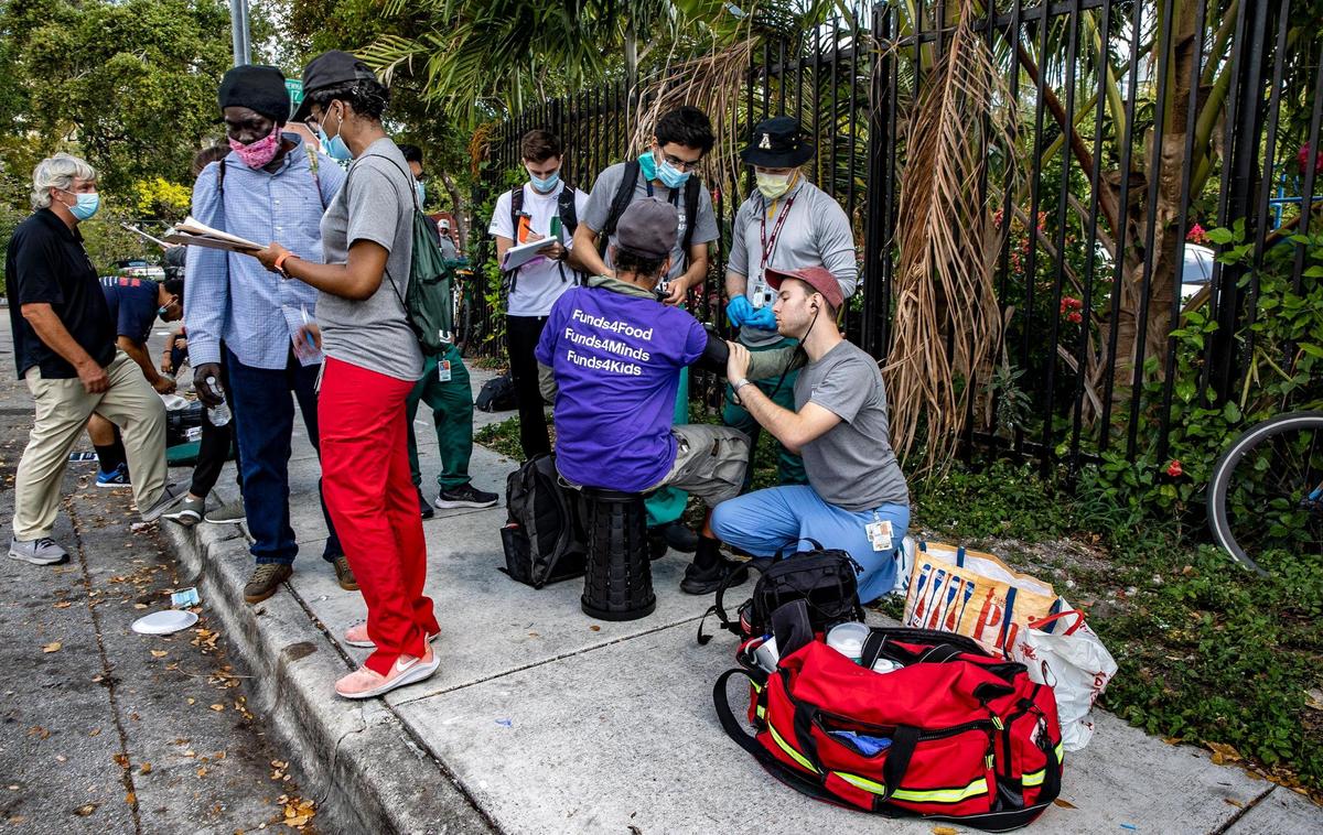 University of Miami medical students and members of the Miami Street Medicine team check on two homeless men during their weekly rounds along Northwest 17th Street in Miami, on March 5, 2022.
