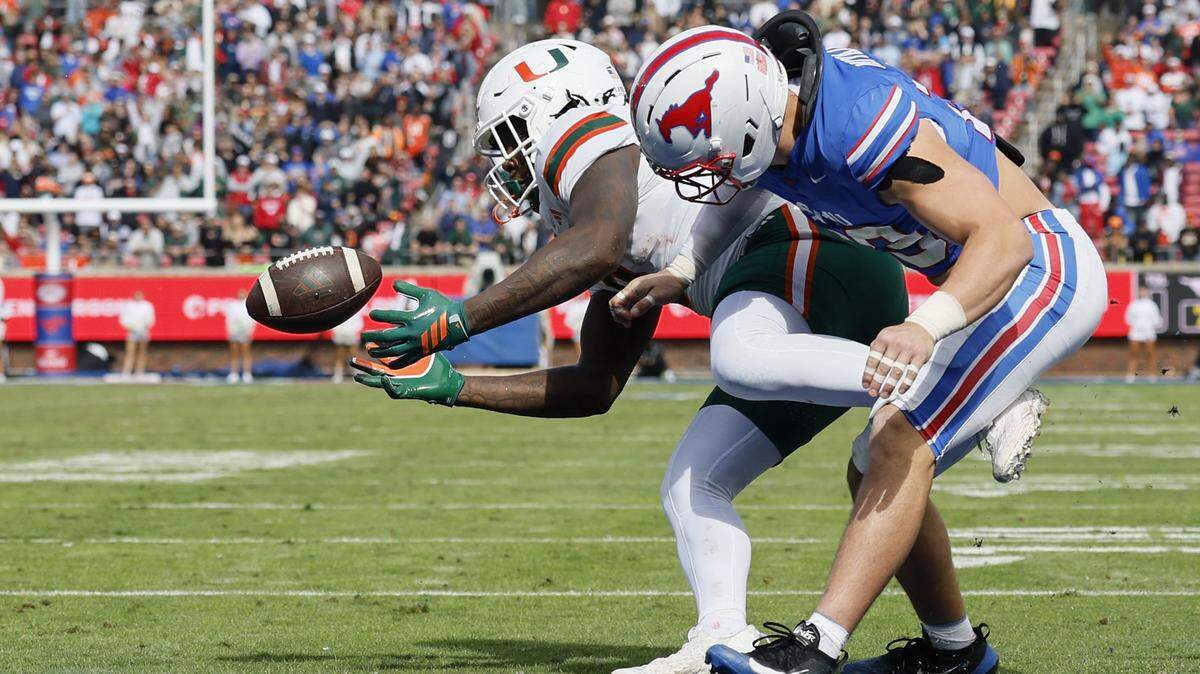 Miami Hurricanes tight end Elija Lofton (9) is hit by Southern Methodist University Mustangs linebacker Brandon Miyazono (29) for an incomplete pass at the goalline and stopping a UM drive during the first half of an NCAA football game at Gerald Ford Stadium on Saturday, November 1, 2025, in Dallas, Texas.