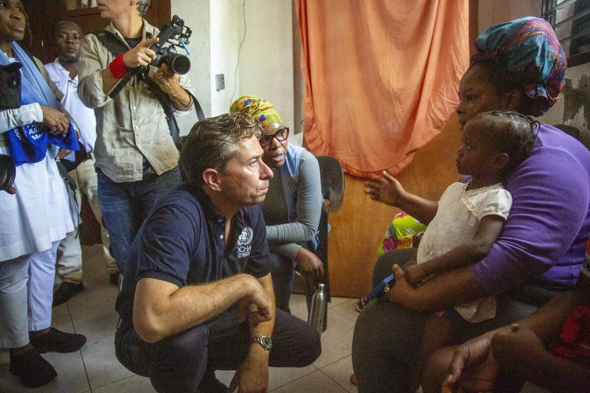 United Nations Humanitarian Chief Tom Fletcher speaks with a mother on Tuesday, September 9, 2025, inside a squalid encampment sheltering 5,000 refugees who have fled from gangs. Fletcher visited the country for three days to get a firsthand look at the worsening humanitarian situation, and how U.N. agencies can help amid their own budget cuts.