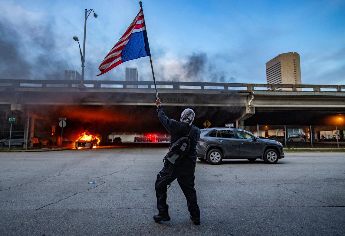 Cars burn near the City of Miami Police headquarters as during George Floyd protest in downtown Miami on Saturday, May 30, 2020.