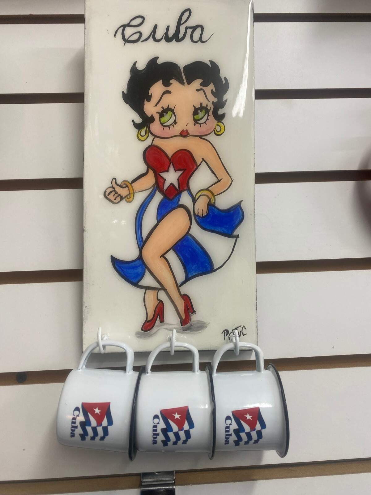 Items featuring figures popular among Cubans—such as the classic American cartoon character Betty Boop — make this set of aluminum cups bearing the Cuban flag unique.