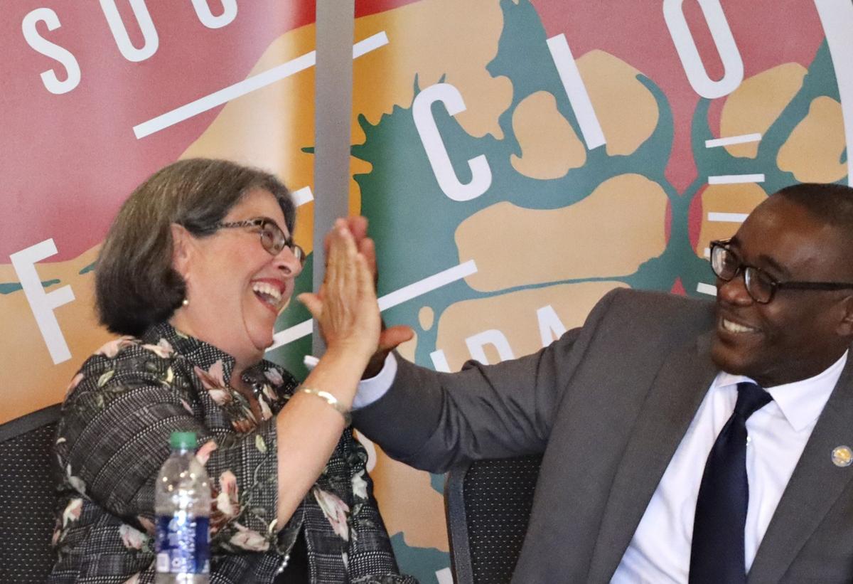 Mayoral candidate Jean Monestime, right, reacts to a comment by Daniella Levine Cava with a “high-five” during the Miami-Dade County Mayoral Candidate Forum held at the Firefighters Memorial Hall in Doral on Monday, October 21, 2019.