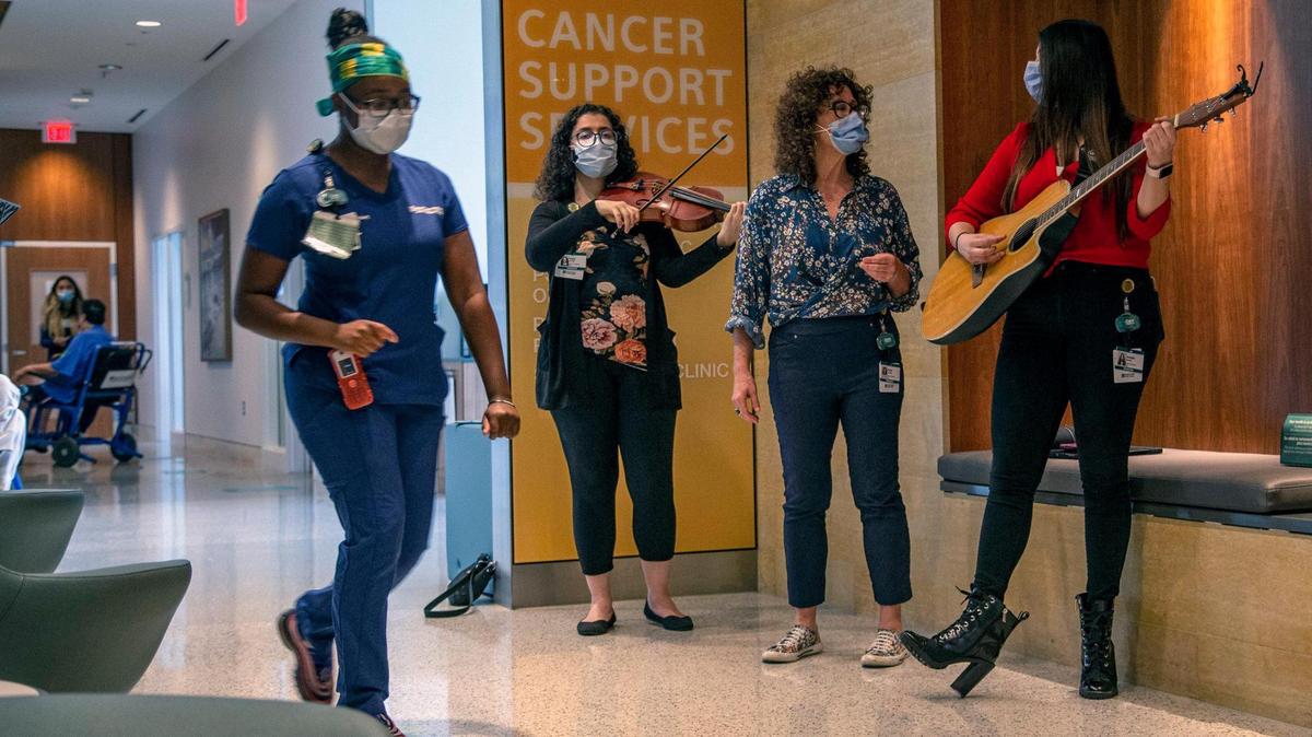 Resident artists Robyn Savitsky, Wendy Pedersen and Amanda Visconti provide cancer support therapy services as they perform in the halls of the Miami Cancer Institute at Baptist Health South Florida in Miami on Wednesday, May 12, 2021.
