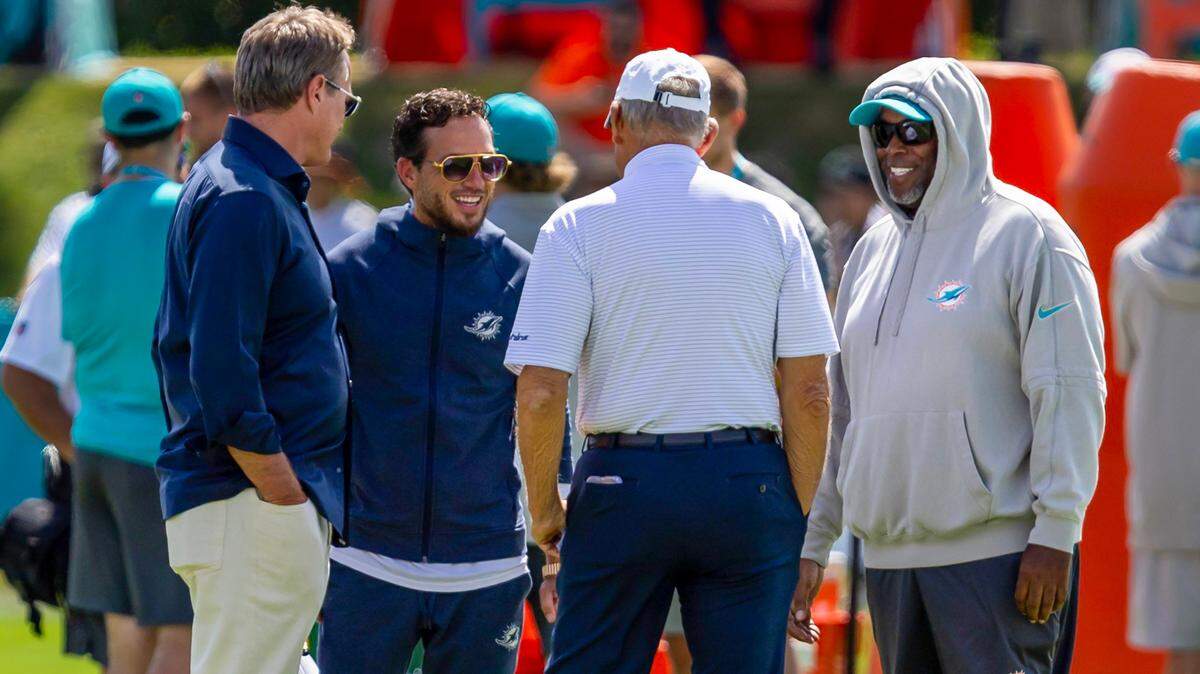 Miami Dolphins owner and chairman Stephen M. Ross, center, speaks with Vice Chairman Tom Garfinkel, far left, and general manager Chris Grier, far right, and head coach Mike McDaniel, second from left, during Day 6 of training camp at Baptist Health Training Complex on Tuesday, July 30, 2024, in Miami Gardens, Fla.