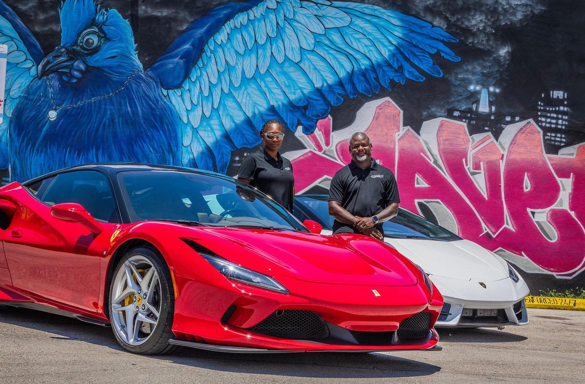 CEO/Founders Marlon and Jessica Wentworth pose next to two luxury vehicles in Wynwood, a red Ferrari F8 Tribute and a white Lamborghini Huracan, from their fleet of exotic cars at Energetic Exotics, a luxury car rental and concierge business, on Friday, July 05, 2024.