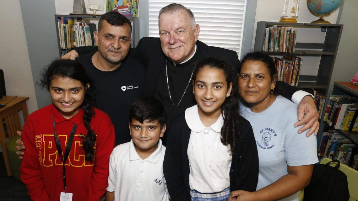 Archbishop Thomas Wenski poses with the Tariq family, Catholics from Pakistan who entered the U.S. as refugees in May 2016.