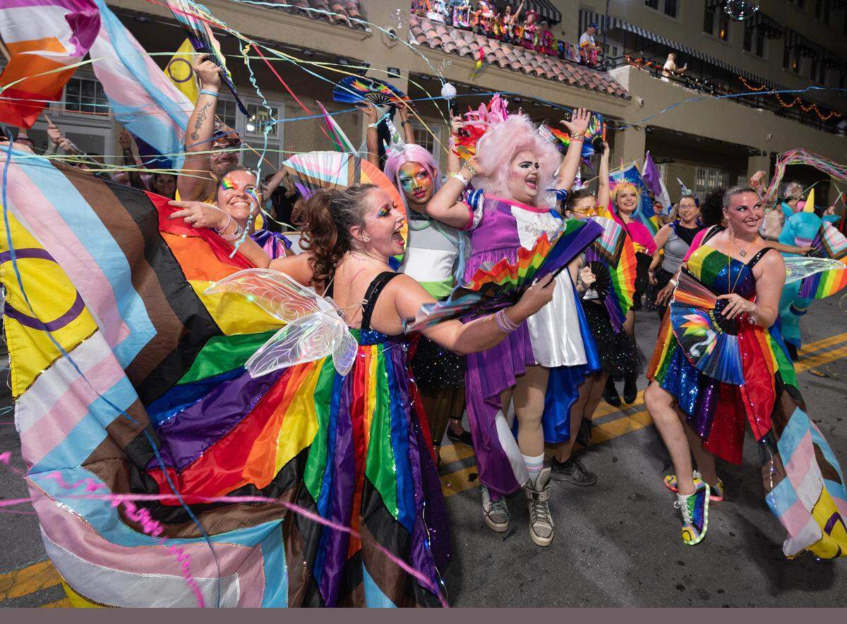 Dancers in lavish rainbow-colored attire perform on Duval Street Saturday, Oct. 28, 2023, in Key West during the Fantasy Fest Parade.