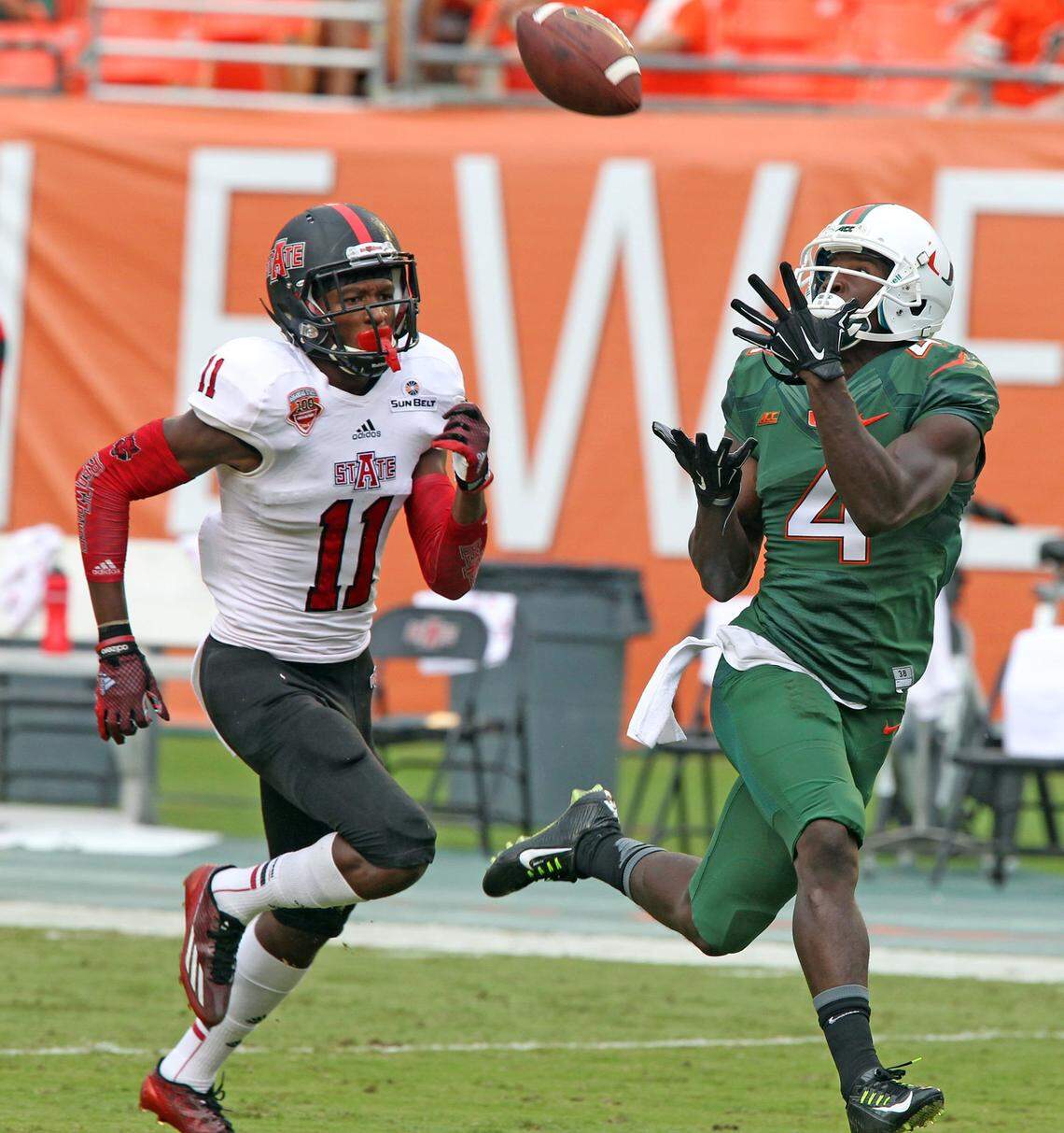 Miami’s Philip Dorsett catches a 64-yard touchdown over Arkansas State’s Sterling Young in the first quarter at Sun Life Stadium in Miami Gardens, Fla., on Saturday, Sept. 13, 2014.