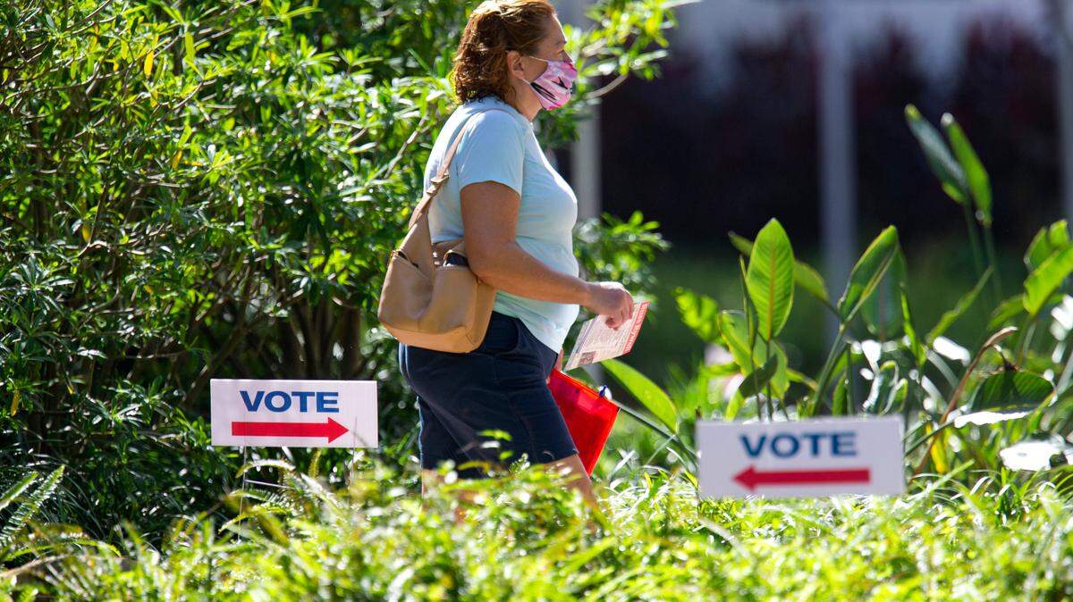 A woman walks outside Miami Beach City Hall to vote during early voting for the general election on Wednesday, October 28, 2020, in Miami Beach.