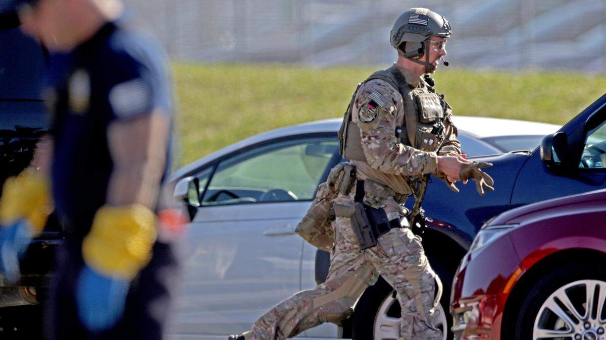 A law enforcement officer rushes toward Marjory Stoneman Douglas High School in Parkland on Wednesday, Feb. 14, 2018.