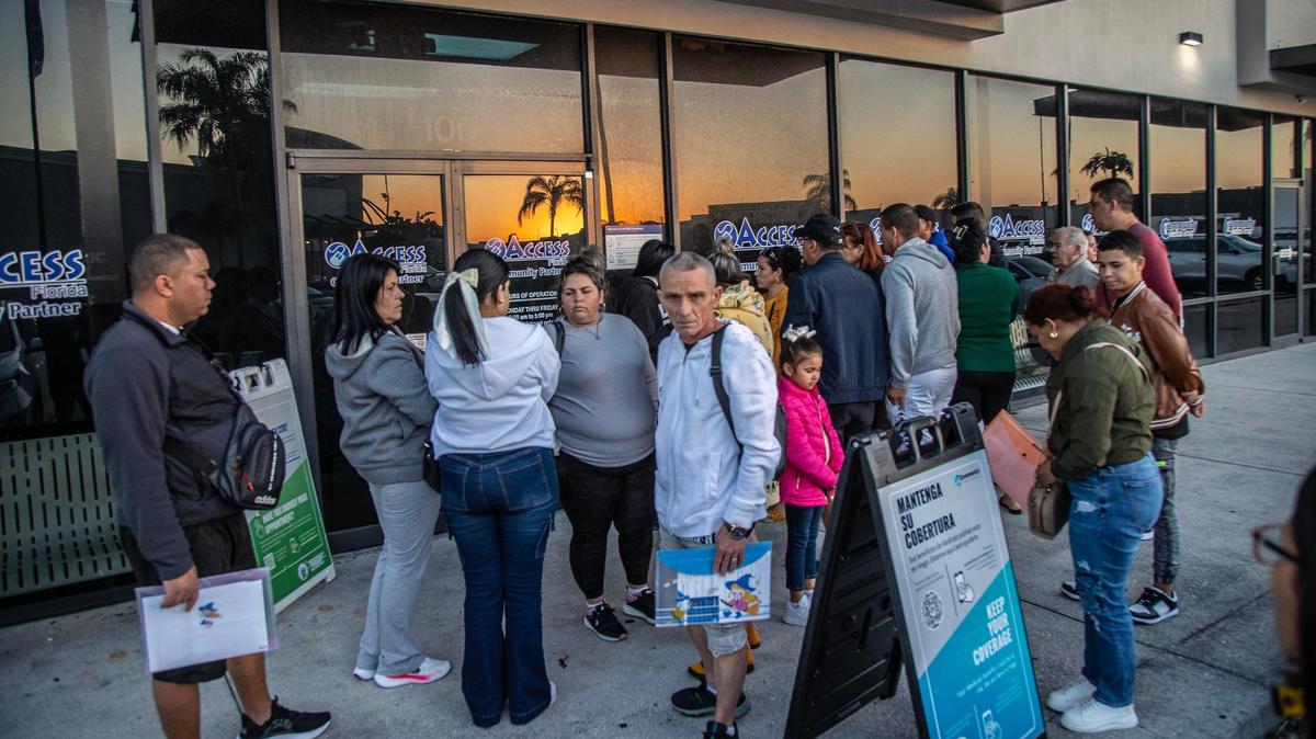 Un grupo de migrantes recién llegados, incluidos cubanos, hacen fila afuera de oficians estatales en Hialeah en el 2024.
