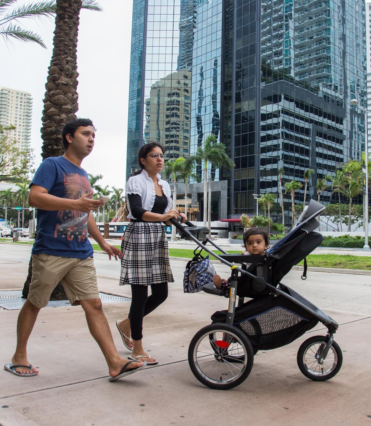 Brickell residents Saurabh Shukla, left, and his wife Niharika Bajpai go for a morning walk with their daughter on Monday, May 28, 2018.