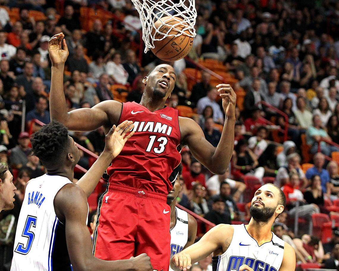 Heat center Bam Adebayo dunks against Magic’s Mo Bamba (left) and Evan Fournier in the fourth quarter of the Miami Heat vs Orlando Magic at AmericanAirlines Arena in Miami on Tuesday, December 04, 2018.