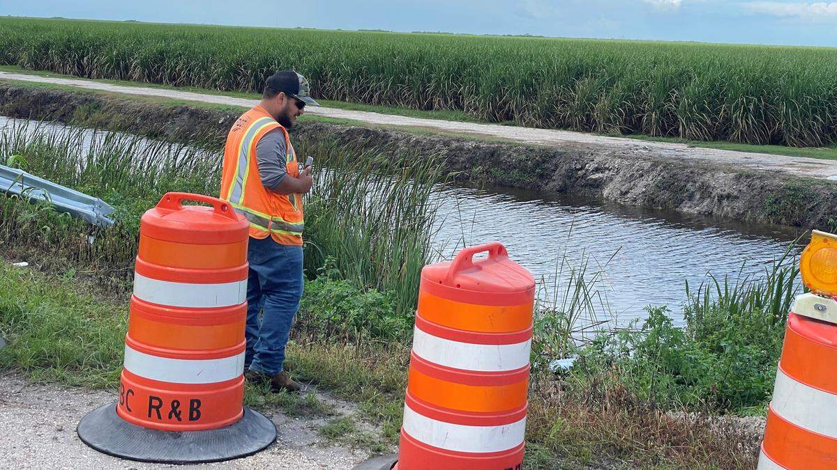 A Florida Department of Transportation worker on Tuesday, Aug. 6, 2024, helps to clear debris from the site of an Aug. 5 crash near Belle Glade, Florida, that killed nine people and injured one.