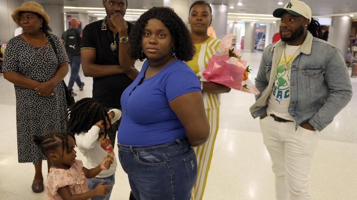 Roselore Touze, in blue, awaits her sister Jeanine Touze on Monday, March 25, 2024, in Miami, Florida at Miami International Airport. To her right, Samuel Paulemon, also awaits his family. Both had relatives coming from Haiti as part of the two-year humanitarian parole program launched over a year ago by President Joe Biden. The passengers traveled onboard a Haiti-based Sunrise Airways flight, which was the first commercial flight out of Haiti to the U.S. in three weeks.