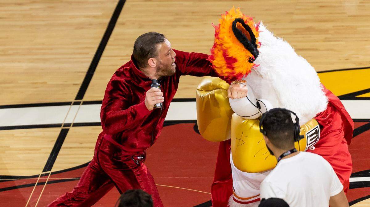 El luchador de artes marciales mixtas Conor McGregor golpea a la mascota del Miami Heat, Burnie, durante el cuarto partido de las finales de la NBA entre el Miami Heat y los Denver Nuggets en el Kaseya Center, el viernes 9 de junio de 2023, en el downtown de Miami.