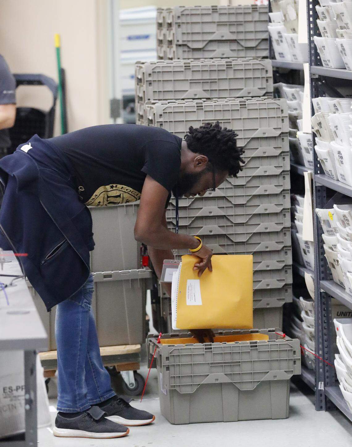 An employee at the Broward County supervisor of elections office places an envelope with ‘over and under’ ballots in a bin during a recount, Wednesday, Nov. 14, 2018, in Lauderhill.