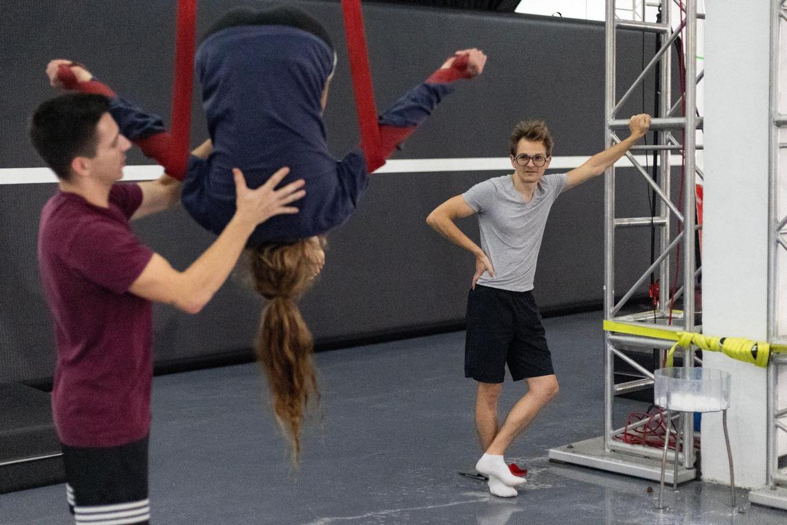 Mila Puletti is coached through rollups on the straps by Nicolas Allard, chief operating officer of the center and instructor, as her partner Nicholas Ferri watches at the Miami Circus Arts Center on July 12, 2023, in Miami, Fla. They form a duo on straps and perform together. When asked what her inspiration is, she answers “Him. He got into this for me, and he’s actually better than me.” One time, Ferri fell from the top of an apparatus, 22 feet high according to Puletti, and then, unharmed, got right back up to go again. “He has no fear,” Puletti said. “I want a little touch of that.”