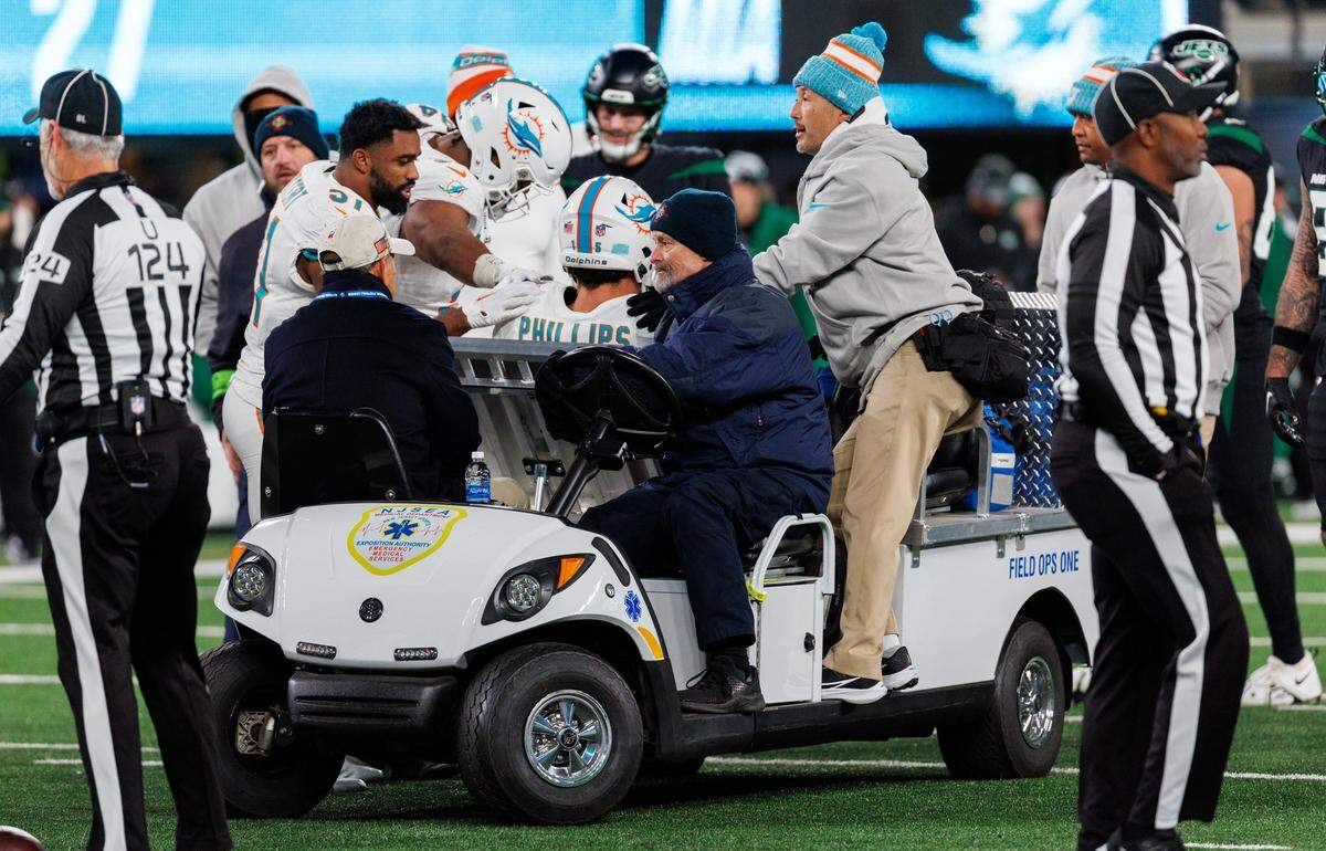 Miami Dolphins linebacker Jaelan Phillips (15) is being carteret out after getting injured in a play during fourth quarter of an NFL football game against the New York Jets at MetLife Stadium on Friday, Nov. 24, 2023 in East Rutherford, New Jersey.