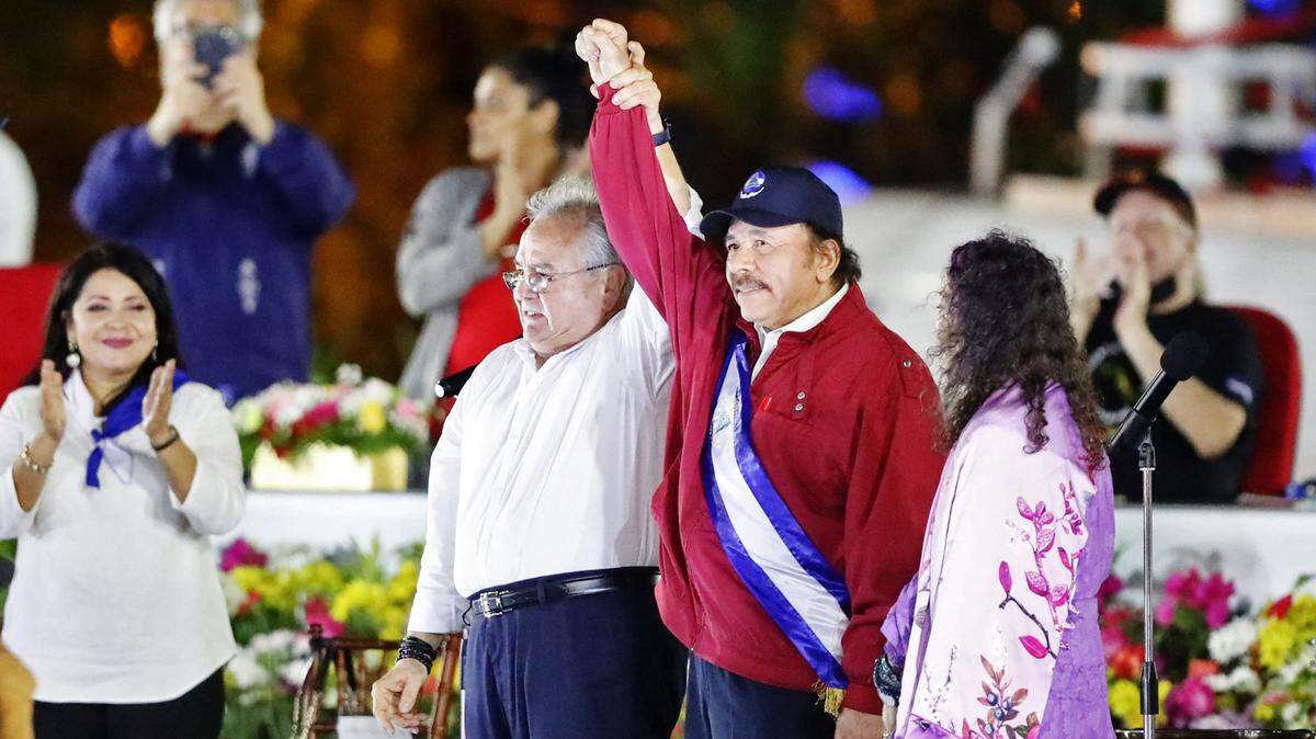 In a photo released by the Venezuelan presidency, Gustavo Porras, president of the Nicaraguan National Assembly, left, raises Nicaraguan President Daniel Ortega’s hand as he is sworn in as president for a fourth straight term.