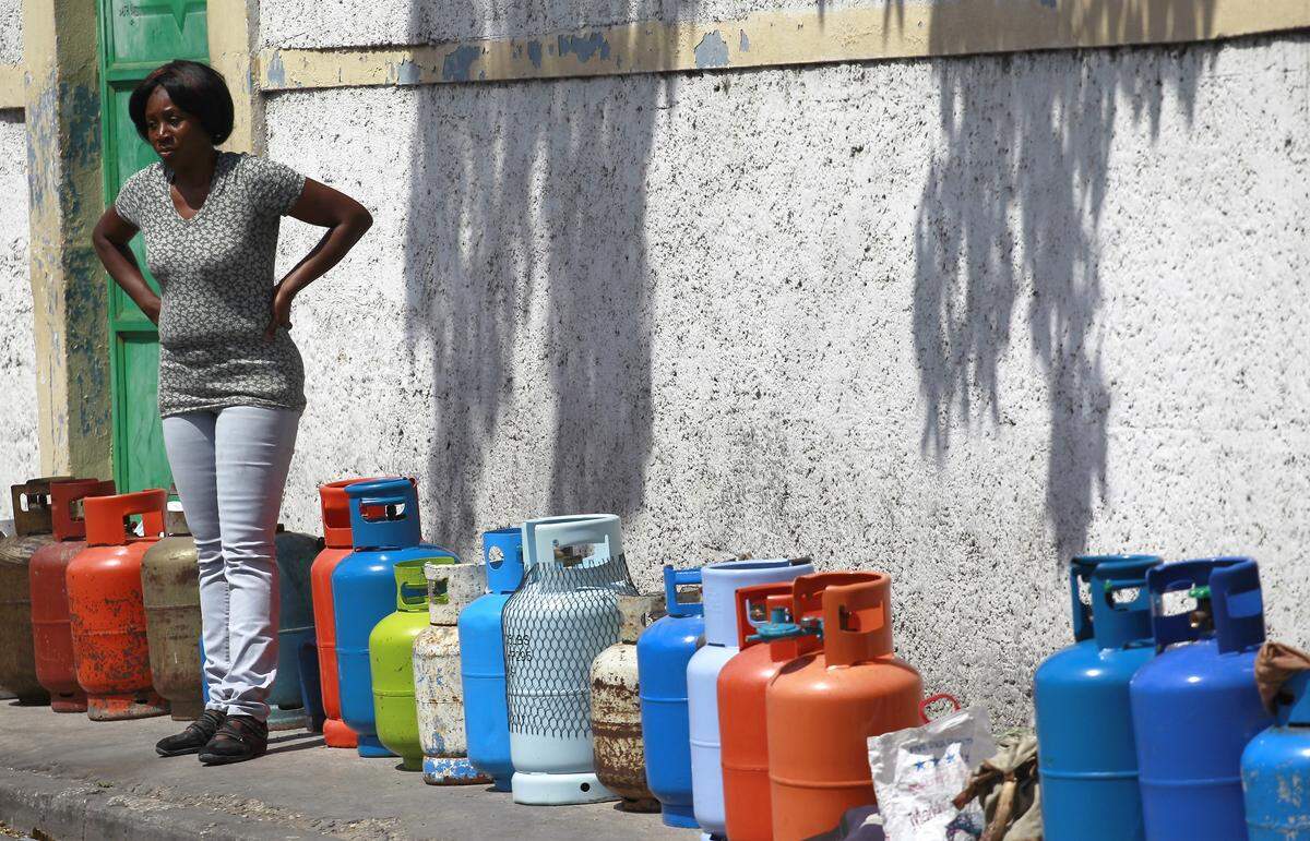 A woman stands among empty propane tanks used to mark the owners’ places in line. During violent protests that shut down the county for 10 days in February 2019, Port-au-Prince residents were forced to endure long lines for fuel, as well as water throughout the capital city.