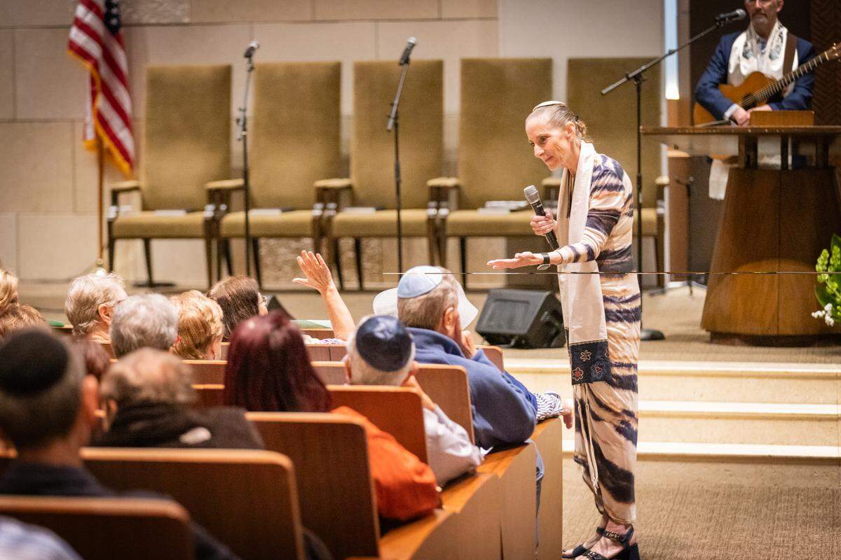 La rabina Robyn Fisher habla con un feligrés durante un servicio especial para dar la bienvenida a los miembros del Templo Beth Or a la congregación del Templo Beth Am.