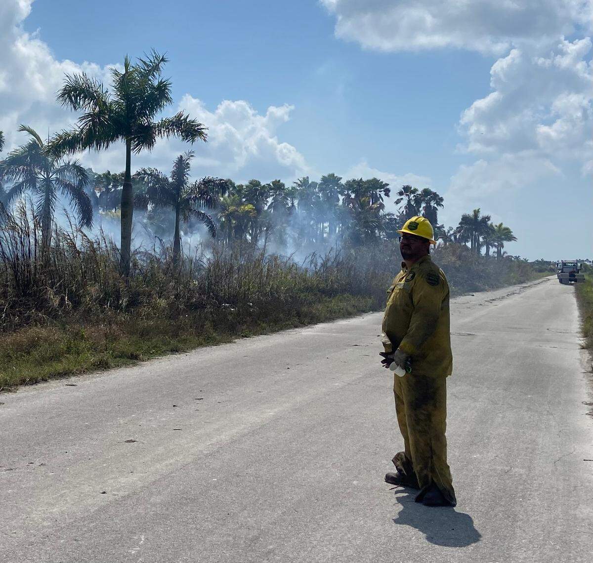Florida Forest Service Firefighter Luis Pineda scans the tree line of a fire at a farm at Southwest 112th Avenue and 268th Street Friday, March 3, 2023.