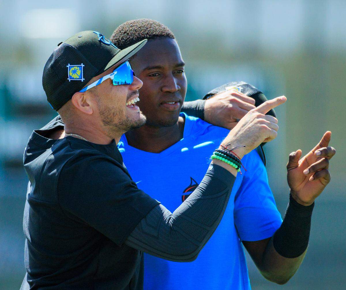 Miami Marlins shortstop Miguel Rojas hugs teammate Jesus Sanchez during the first full-squad spring training workout at Roger Dean Stadium on Monday, March 14, 2022 in Jupiter, FL.