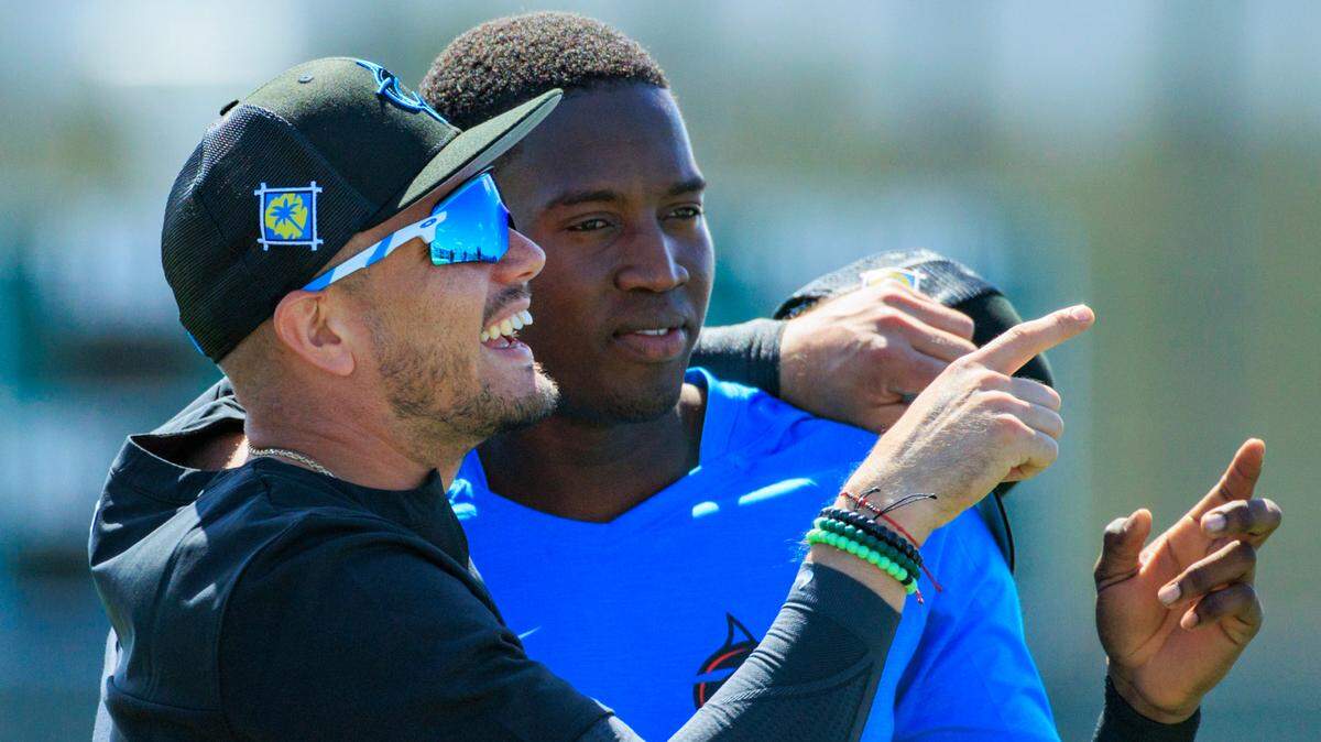 Miami Marlins shortstop Miguel Rojas hugs teammate Jesus Sanchez during the first full-squad spring training workout at Roger Dean Stadium on Monday, March 14, 2022 in Jupiter, FL.