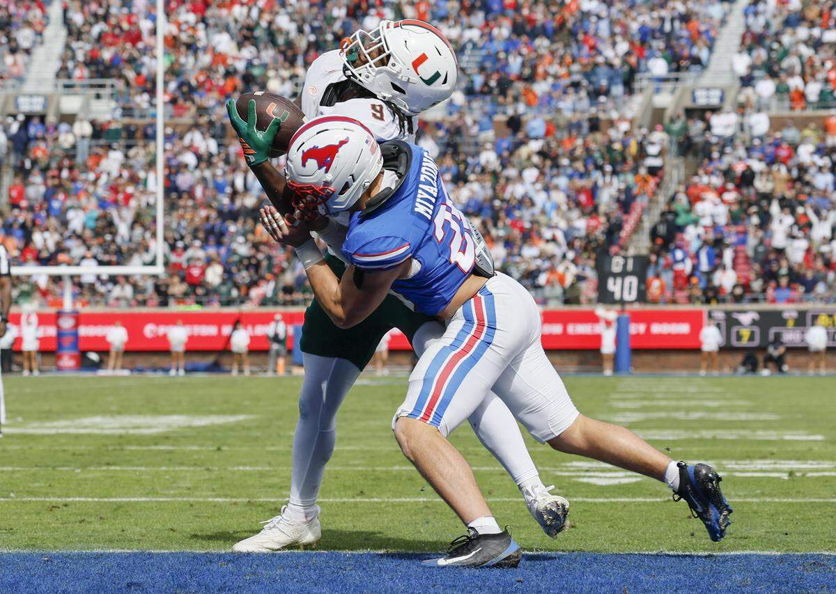 Miami Hurricanes tight end Elija Lofton (9) is hit by Southern Methodist University Mustangs linebacker Brandon Miyazono (29) for an incomplete pass at the goalline and stopping a UM drive during the first half of an NCAA football game at Gerald Ford Stadium on Saturday, November 1, 2025, in Dallas, Texas.