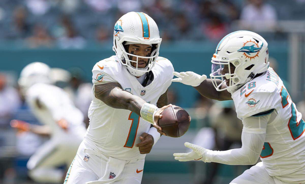 Miami Dolphins quarterback Tua Tagovailoa (1) passes the ball to running back De'Von Achane (28) in the first half of their NFL game at Hard Rock Stadium on Sunday, Sept. 14, 2025, in Miami Gardens, Fla.