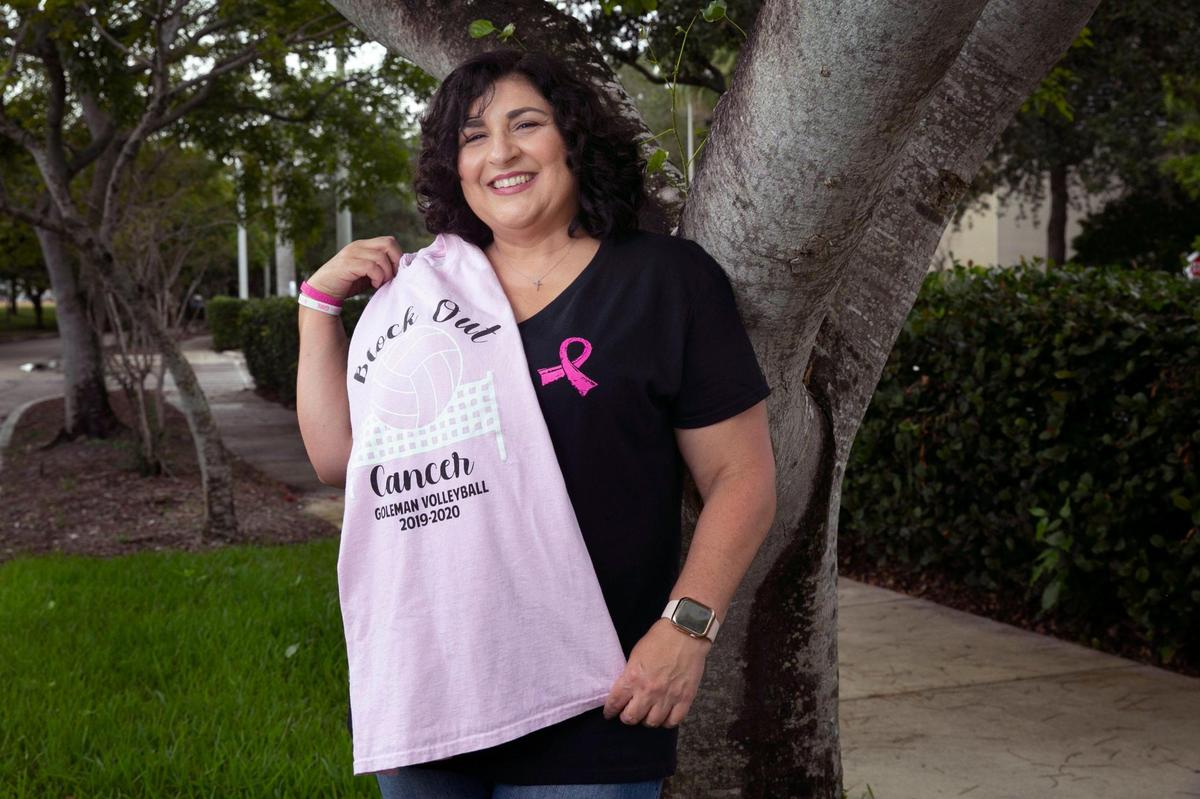 Marlen Acosta-García, sobreviviente de cáncer de seno y paciente de la Dra. Lauren Carcas en la ubicación de Plantation del Miami Cancer Institute de Baptist Health, sostiene una camiseta de la preparatoria Barbara Goleman en Miami Lakes, donde ahora enseña Derecho y es entrenadora asistente de voleibol, en una imagen del 8 de octubre de 2021. 