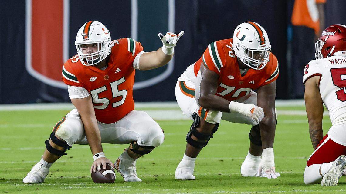 Miami Hurricanes center Matt Lee (55) gestures and Miami Hurricanes offensive lineman Javion Cohen (70) at the line of scrimmage during the game against Miami of Ohio Redhawks at Hard Rock Stadium in Miami Gardens, Florida on Friday, September 1, 2023.