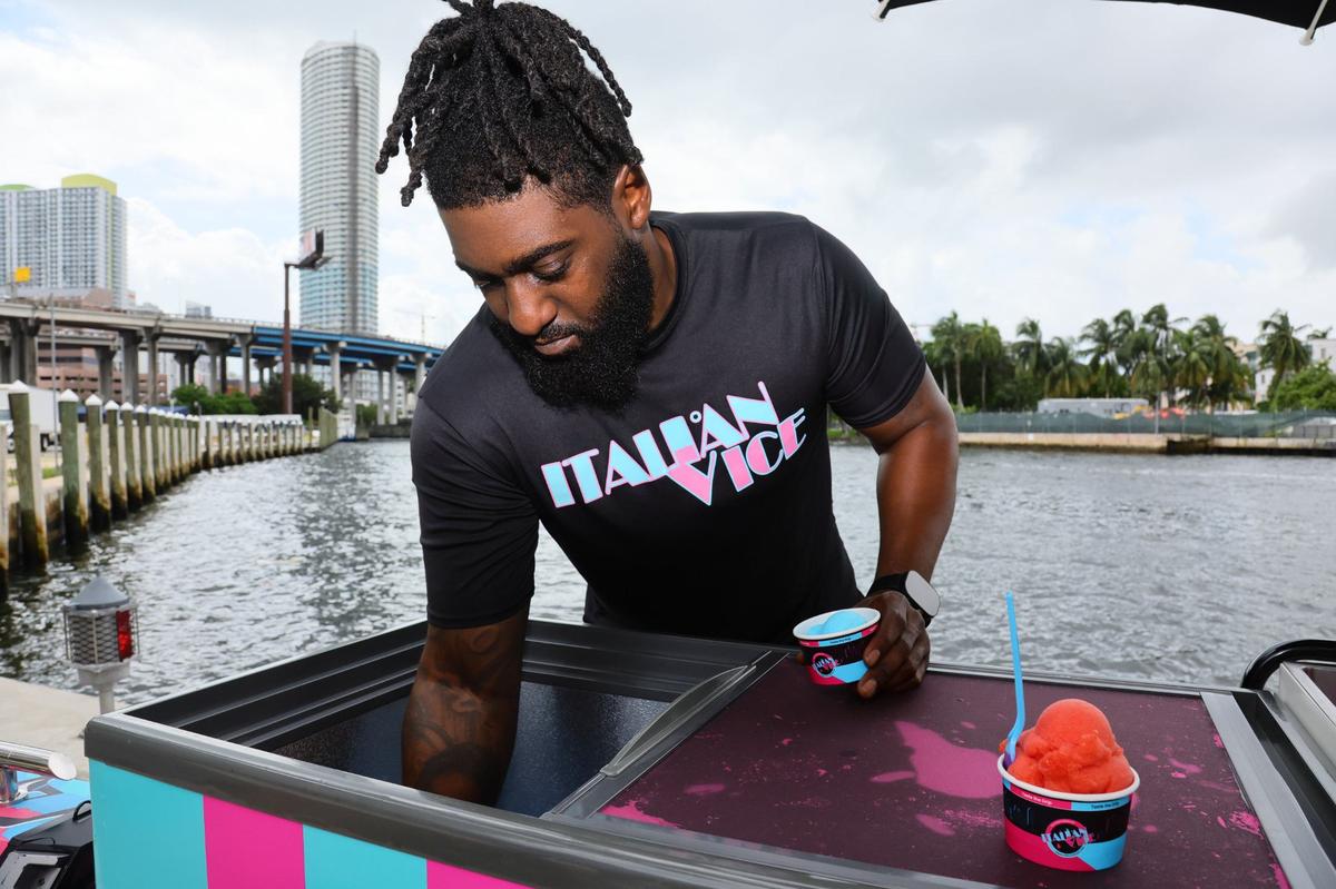 Aamir Taylor, owner of Italian Vice, a Miami-based water ice company, is photographed with his mobile cart serving a scoop of Nipsey Blue water ice flavor by the Miami River in downtown Miami on Friday, Oct. 11, 2024.