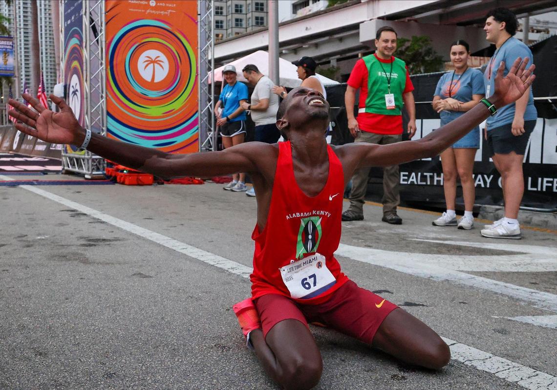 Exhausted Solomon Kagimbi of Kenya kneels after crossing the finishing line to win the Half Marathon as over 18,000 athletes and runners participated in the 2025 Life Time Miami Marathon and Half on February 2, 2024, in downtown Miami, Florida.
