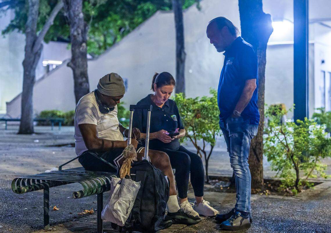 Ron Book, chair of the Miami-Dade County Homeless Trust, and Victoria Mallette, the Trust’s executive director, talk to a homeless man in downtown Miami as part of an overnight census on Aug. 21, 2025.