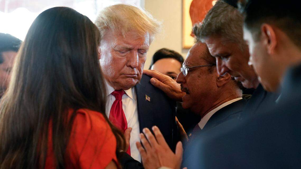 Former President Donald Trump prays with pastor Mario Bramnick, in glasses next to Trump, and others at Versailles restaurant on Tuesday, June 13, 2023, in Miami. Trump appeared in federal court Tuesday on dozens of felony charges accusing him of illegally hoarding classified documents and thwarting the Justice Department’s efforts to get the records back. (AP Photo/Alex Brandon)