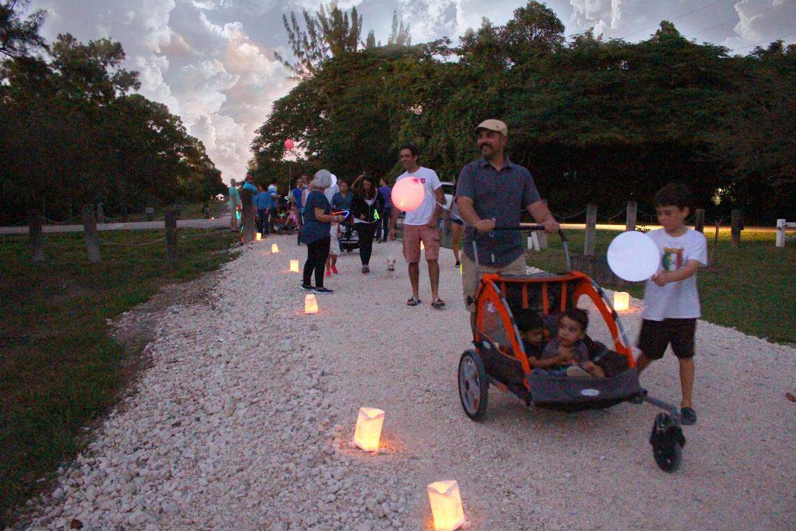 People take a nighttime stroll along the land that makes up the southern portion of the Ludlam Trail. Lit up for an evening event in December 2016, the trail has been since been fenced off to prepare to cleaning up contaminated soil ahead of Miami-Dade purchasing the five-mile trail from Florida East Coast Industries. Miami-Dade plans to spend close to $100 million converting the abandoned railway into a park.