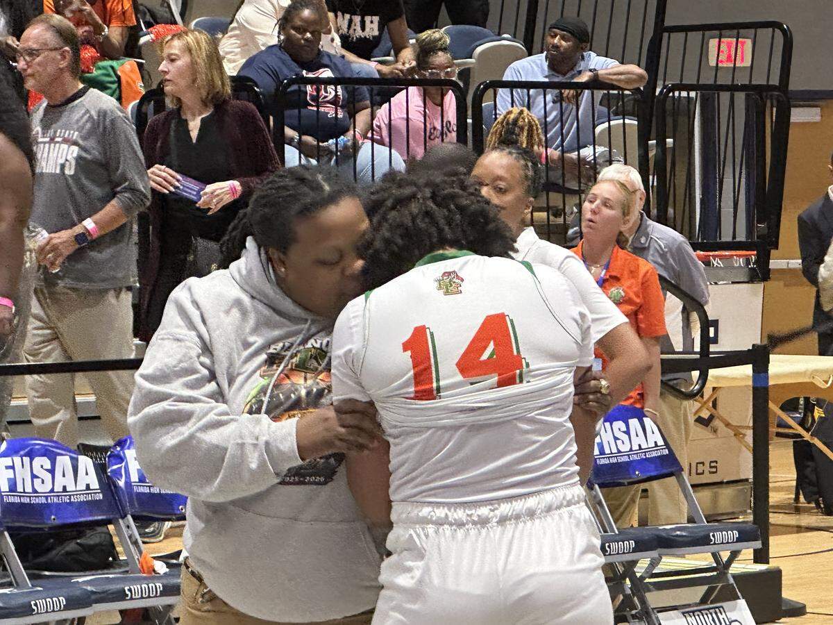 Blanche Ely’s Isyss Mims (14) is consoled by one of her coaches after the Tigers lost 56-54 to Pensacola Washington in the Class 5A girls’ basketball state championship game at UNF Arena in Jacksonville, Fla.