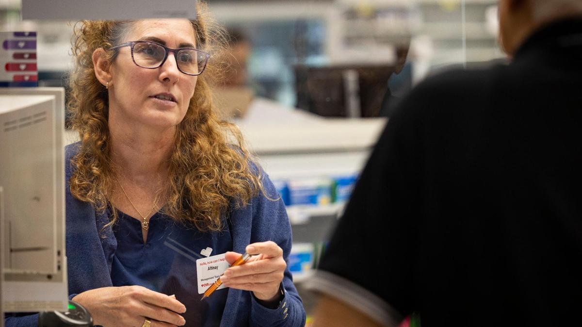 Una farmaceuta ayuda a un cliente de habla hispana durante una visita a una farmacia CVS el lunes 16 de octubre de 2023 en Westchester, Miami. La directora de los CDC, Mandy Cohen, habló ese día en la farmacia sobre la importancia de llegar a la comunidad hispana con la nueva vacuna RSV COVID-19.